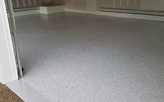 A garage with a white floor and a white door.