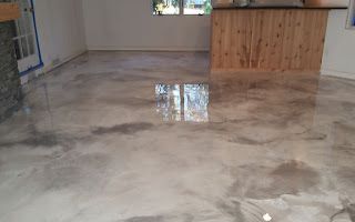 A living room with a concrete floor and a wooden counter.