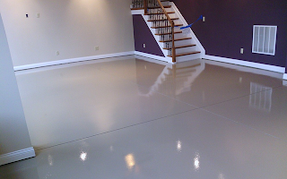 A basement with a staircase and a shiny floor.