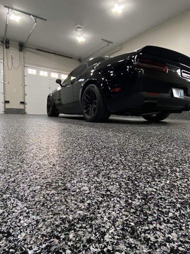 A black dodge challenger is parked in a garage.