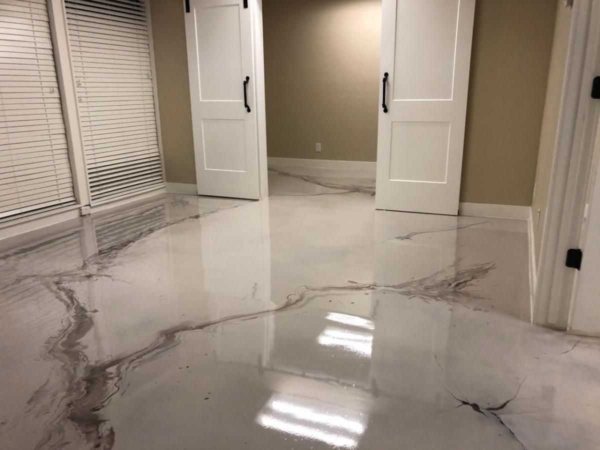 A room with a white marble floor and white doors.