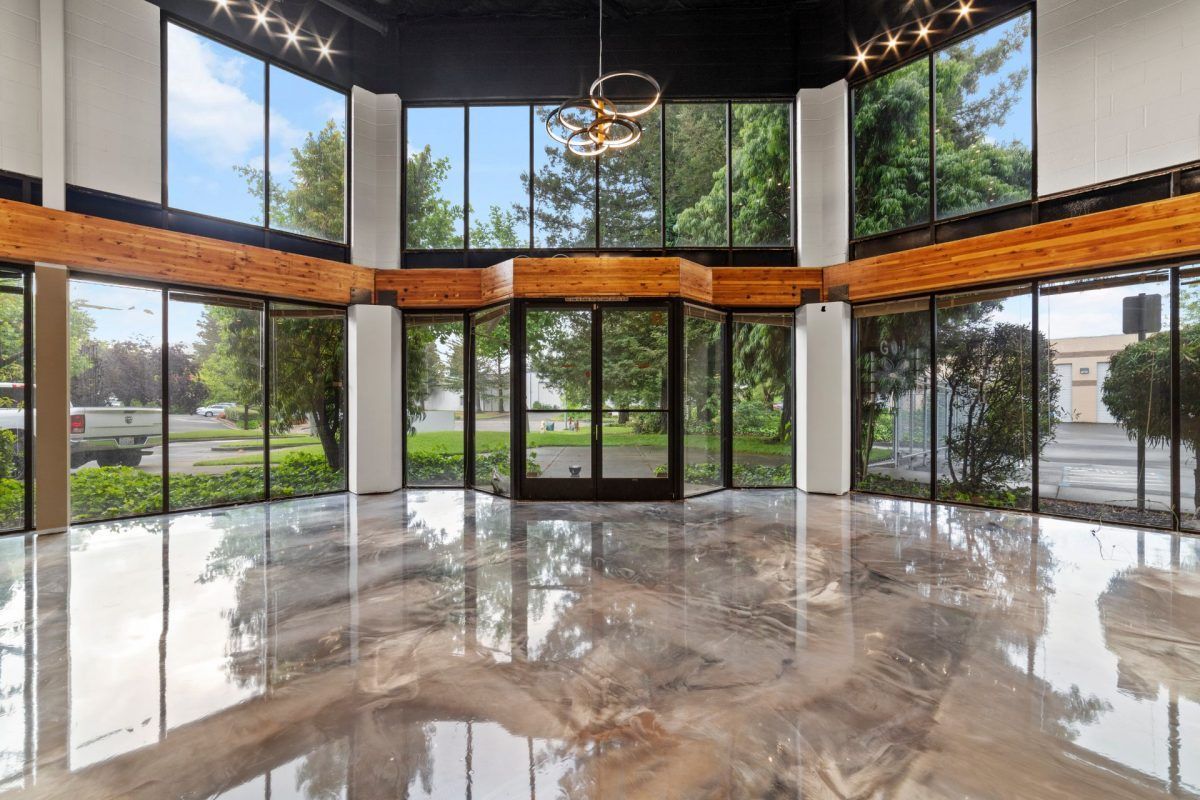 A large empty room with a lot of windows and a shiny floor.