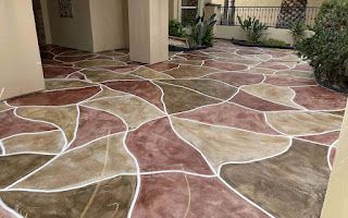 A concrete patio with a geometric pattern painted in different colors.