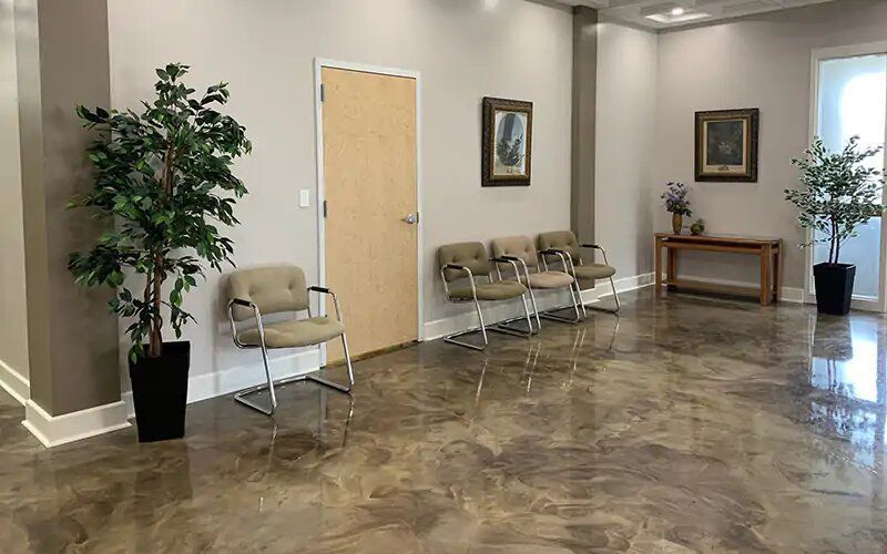 A waiting room with chairs and a potted plant.