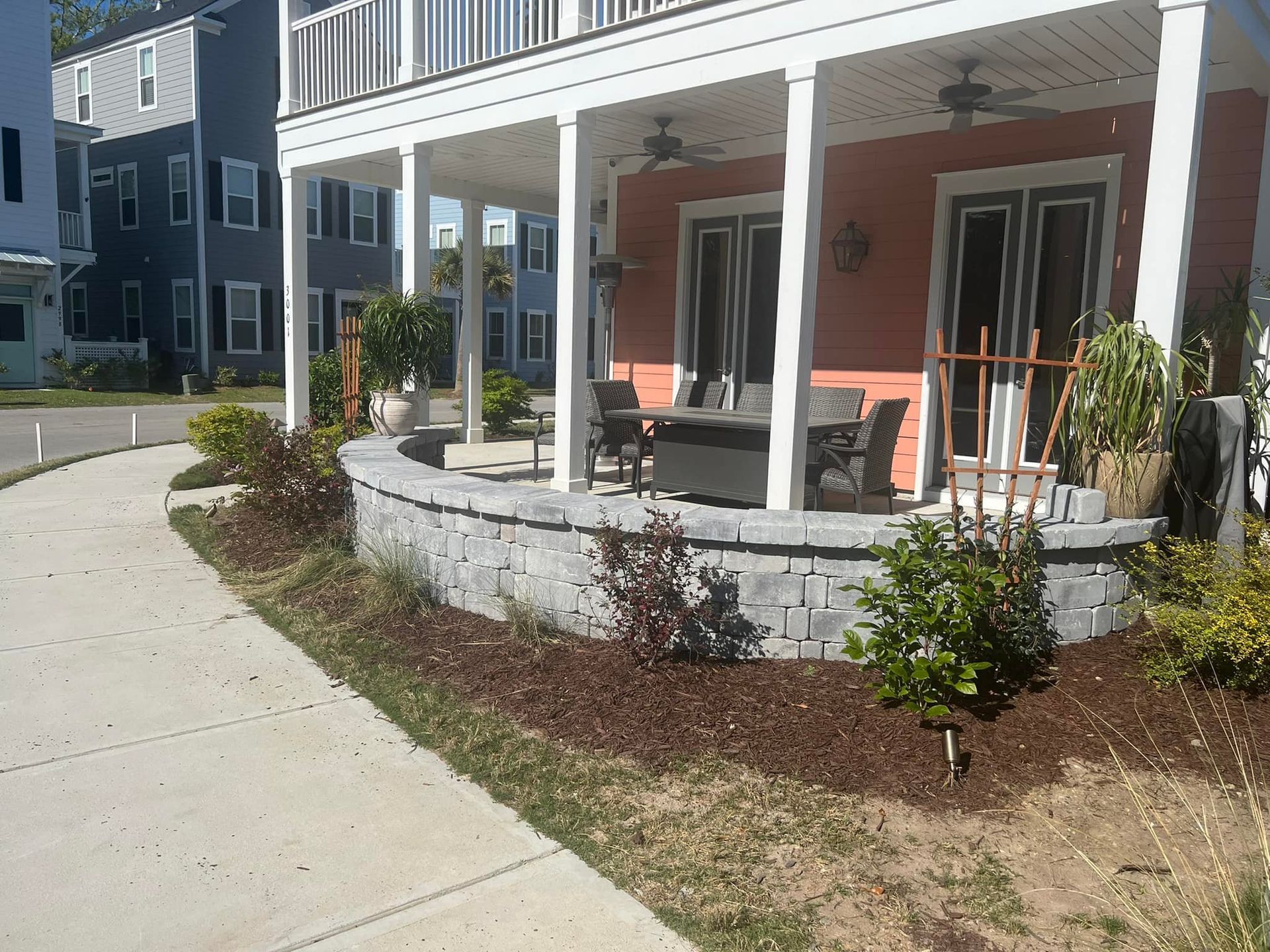 A house with a large porch and a brick wall - Mount Pleasant, SC - C&B Landscape LLC