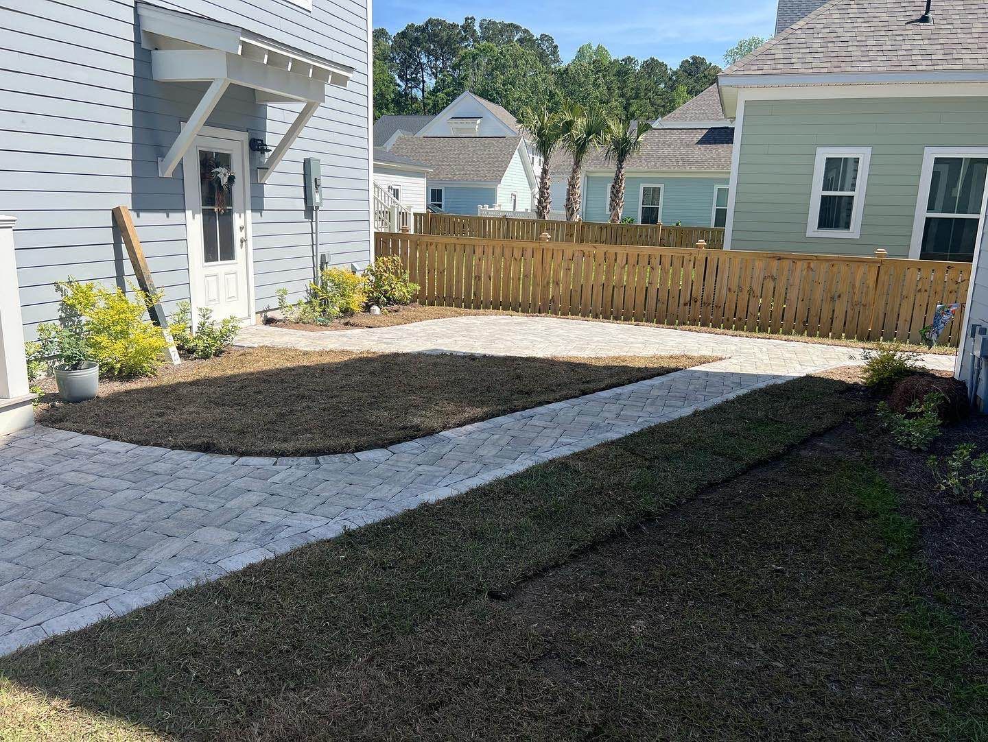 A house with a wooden fence and a walkway in front of it - Mount Pleasant, SC - C&B Landscape LLC