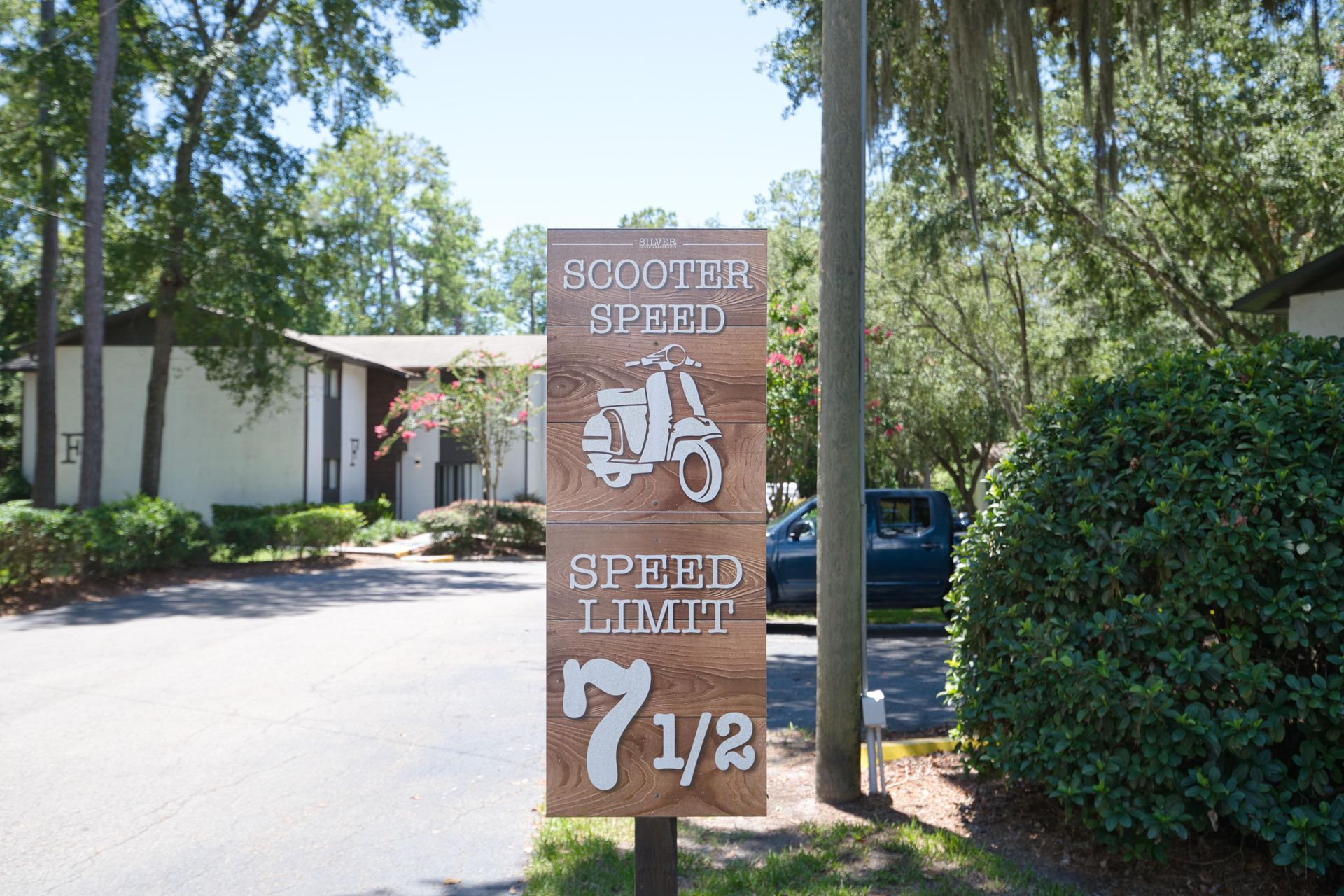 A wooden sign that says scooter speed limit 7 1/2