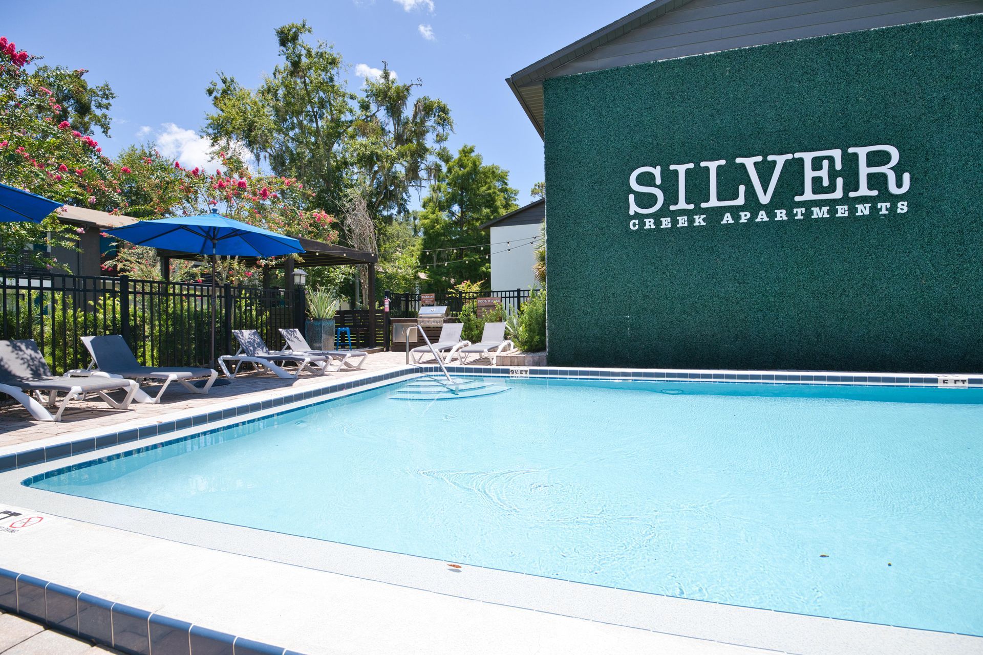 A large swimming pool in front of a building that says silver