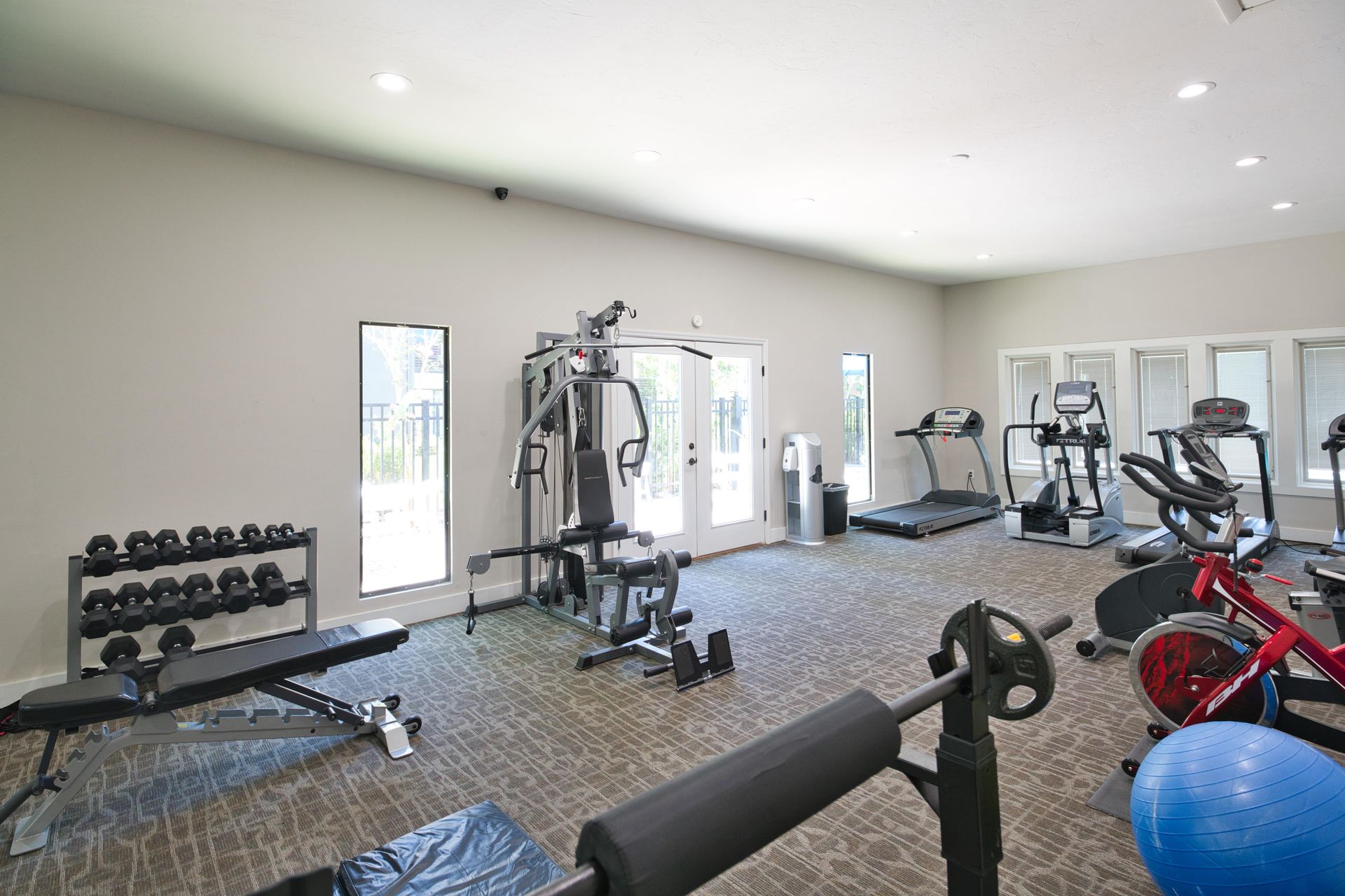 A large gym filled with lots of exercise equipment.