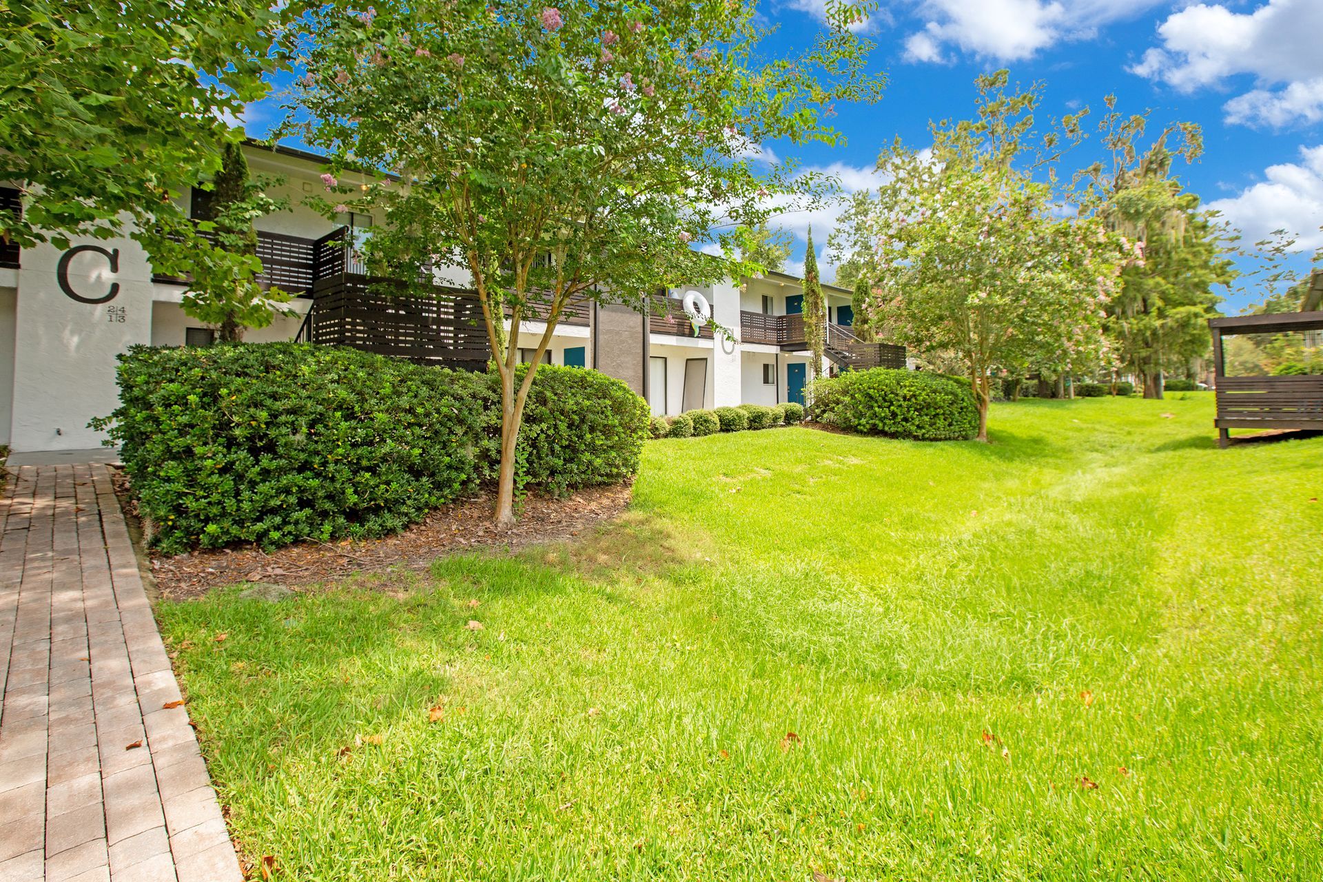A large lawn in front of a building with a walkway leading to it.