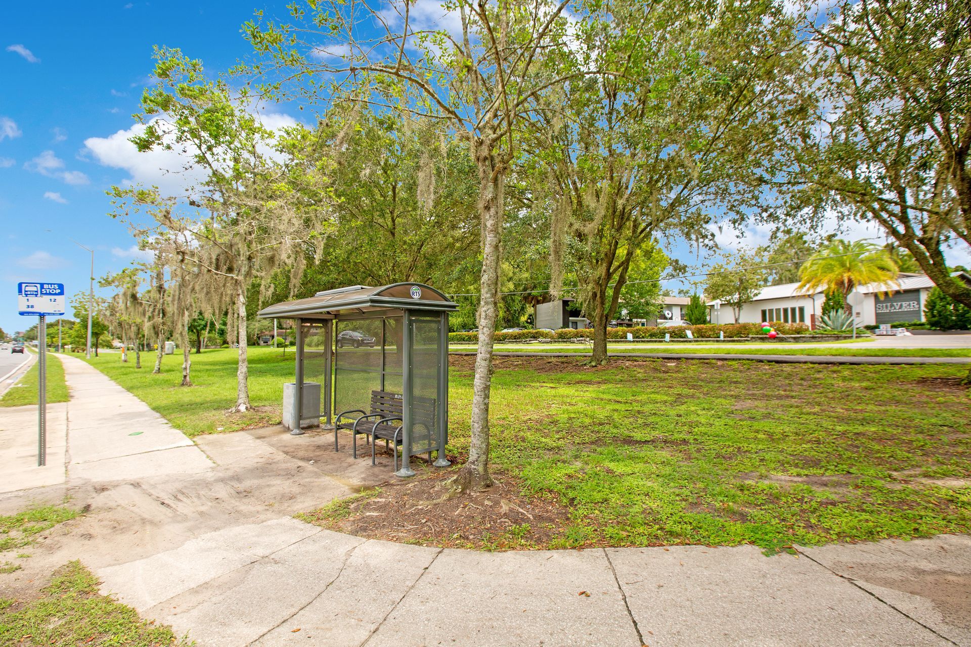 There is a bus stop in the middle of a park.