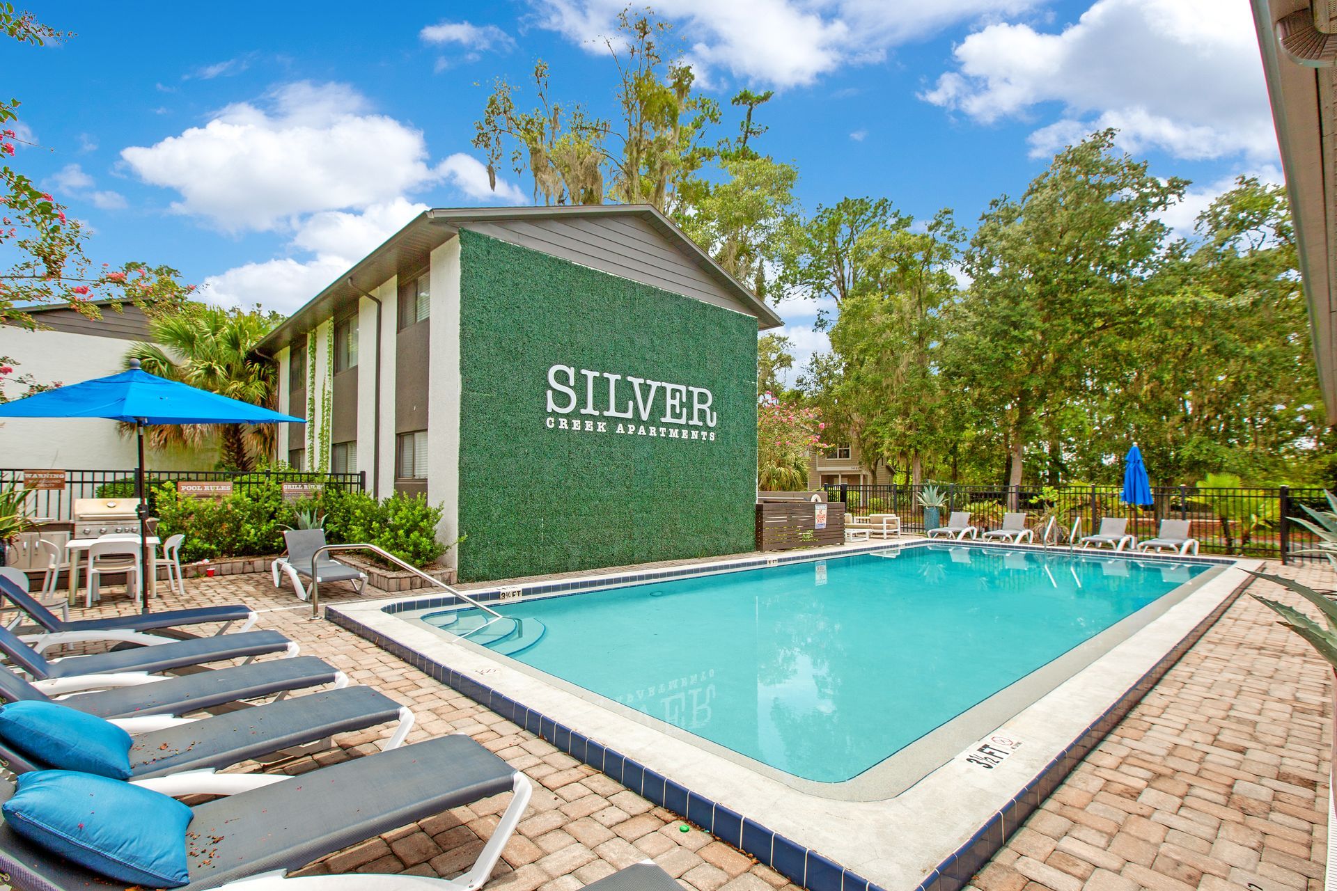 There is a large swimming pool in front of a building.