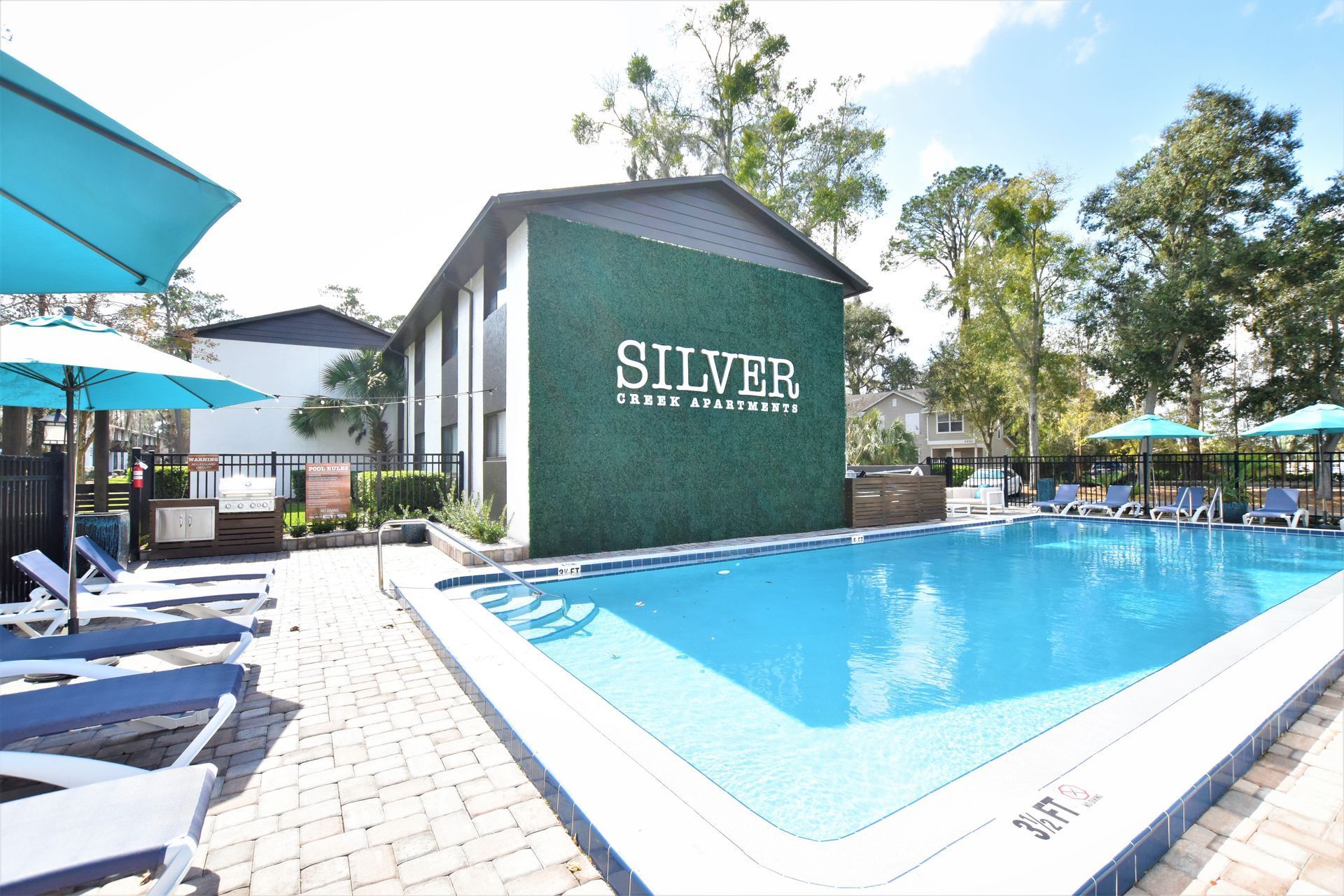A large swimming pool in front of a building that says silver