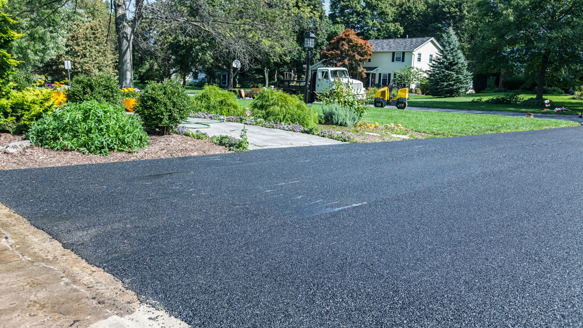 A driveway is being paved in front of a house.