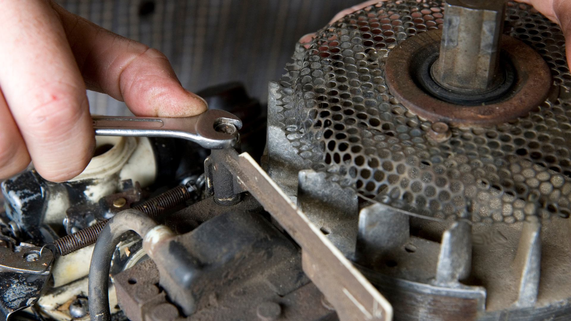 A man is working on an engine in a garage.