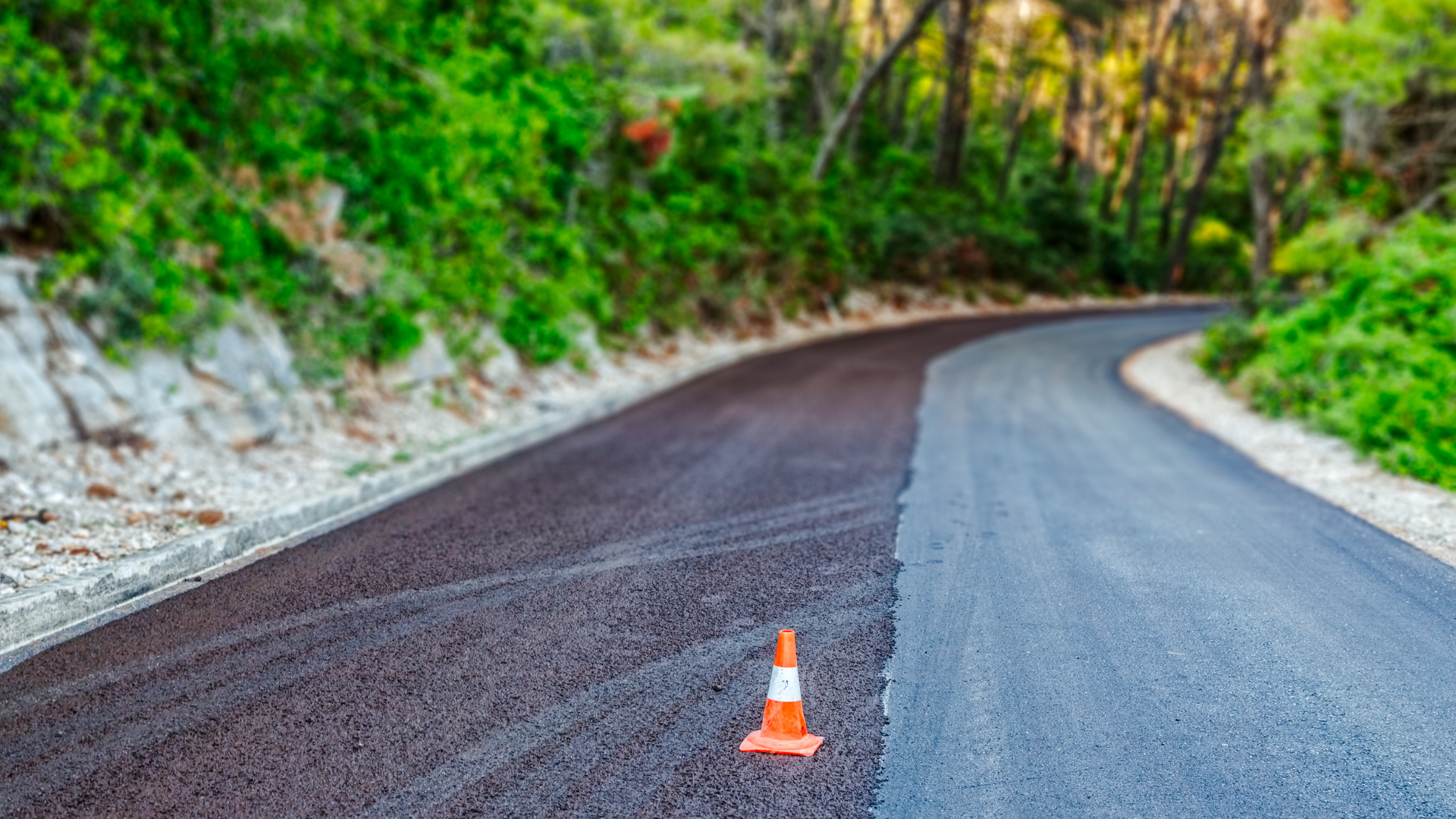 There is a traffic cone on the side of the road.