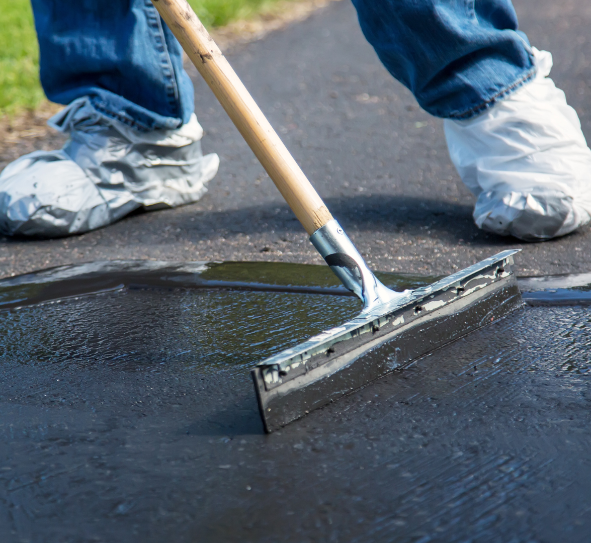 A person is using a squeegee on a wet road