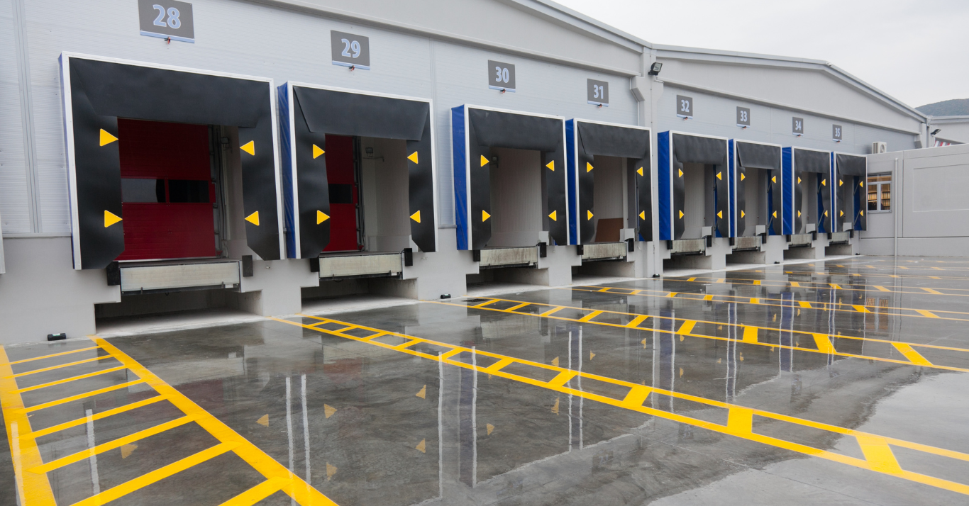 A row of loading docks in a warehouse on a rainy day.