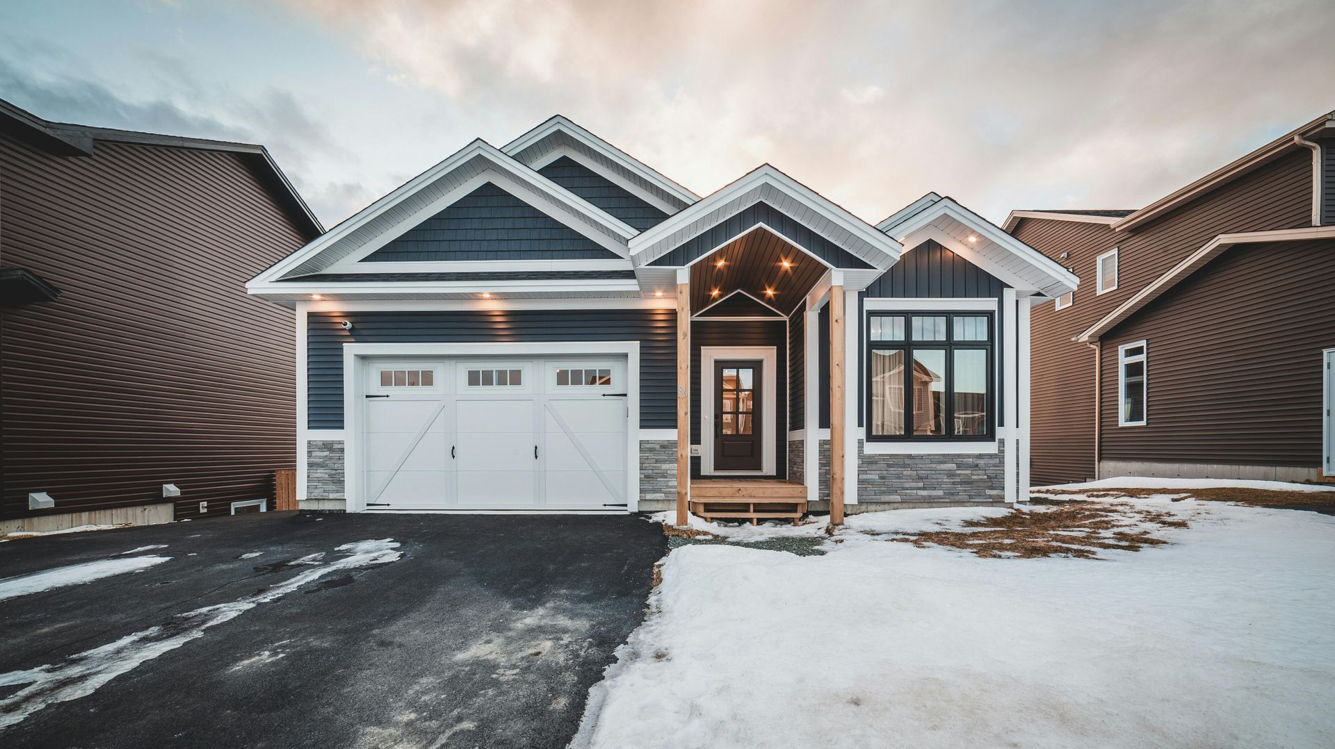 A house with a garage and a driveway covered in snow.