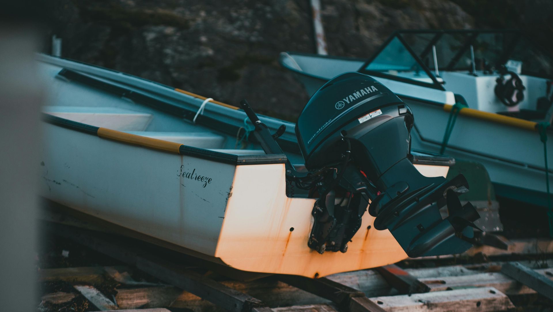 A boat with a motor attached to it is sitting on a wooden dock.