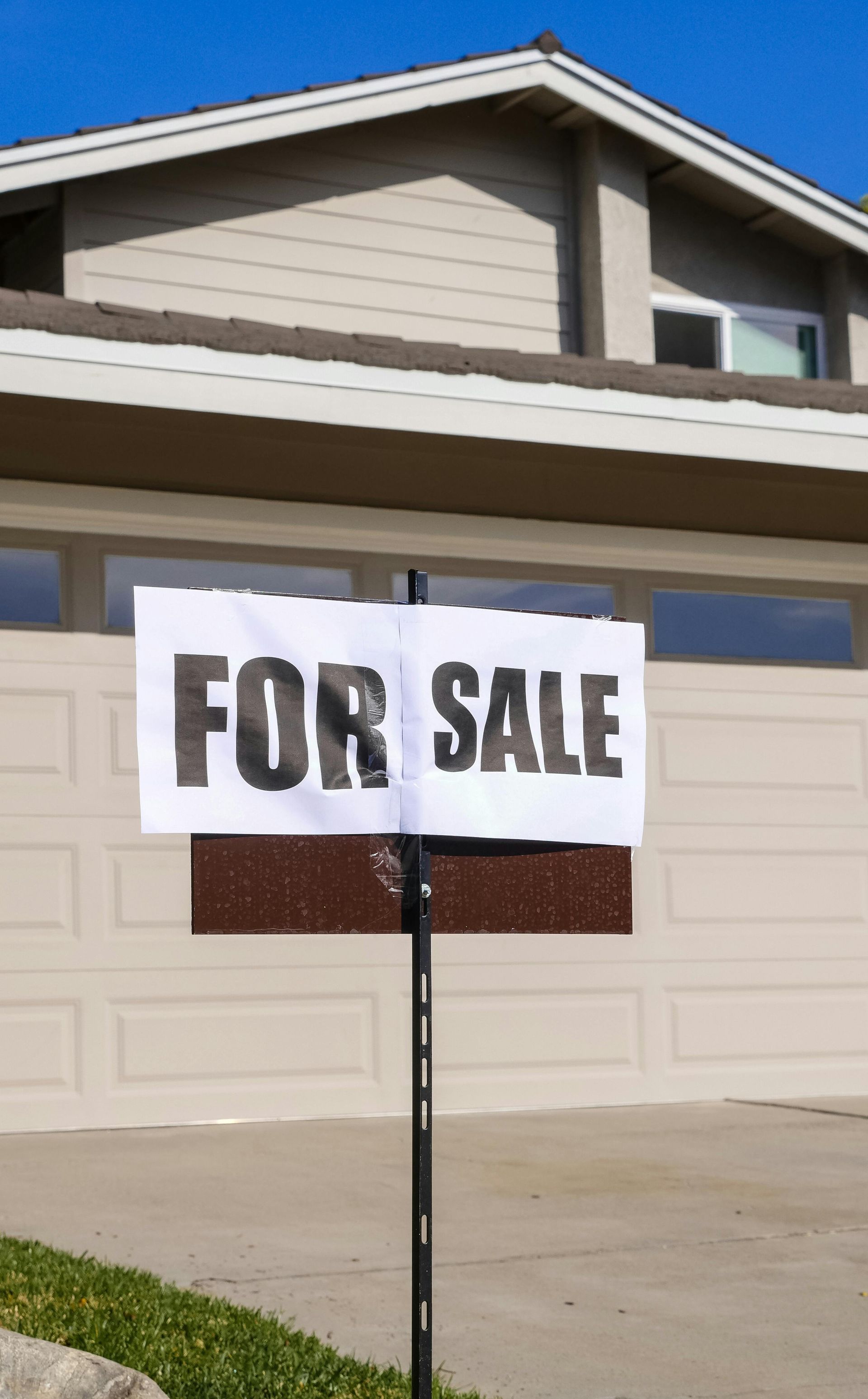 A for sale sign is in front of a house.