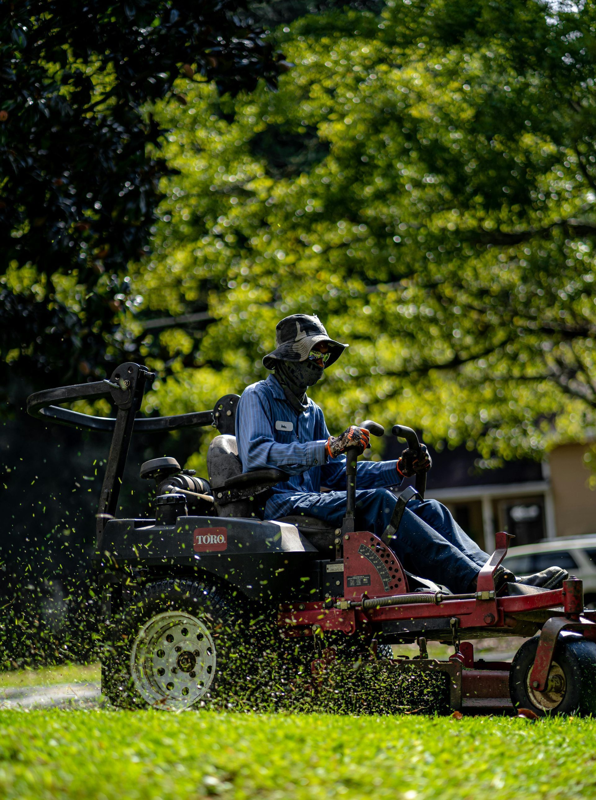 A man is riding a lawn mower on a lush green lawn.