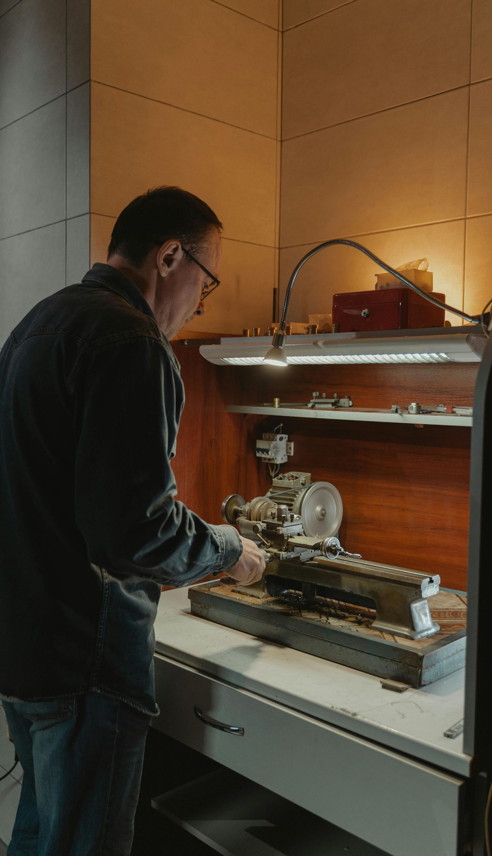 A man is working on a machine in a workshop.