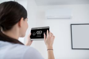 woman turning on ac unit through tablet