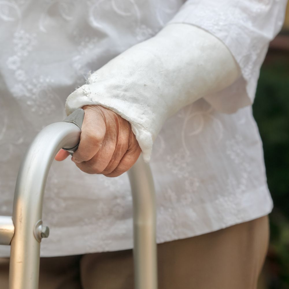 A person with a cast on their arm is using a walker