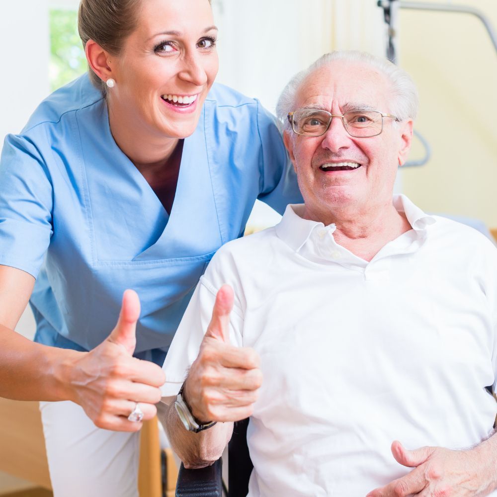 A nurse is giving an elderly man a thumbs up