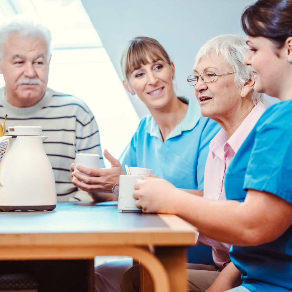 A group of people are sitting around a table drinking coffee