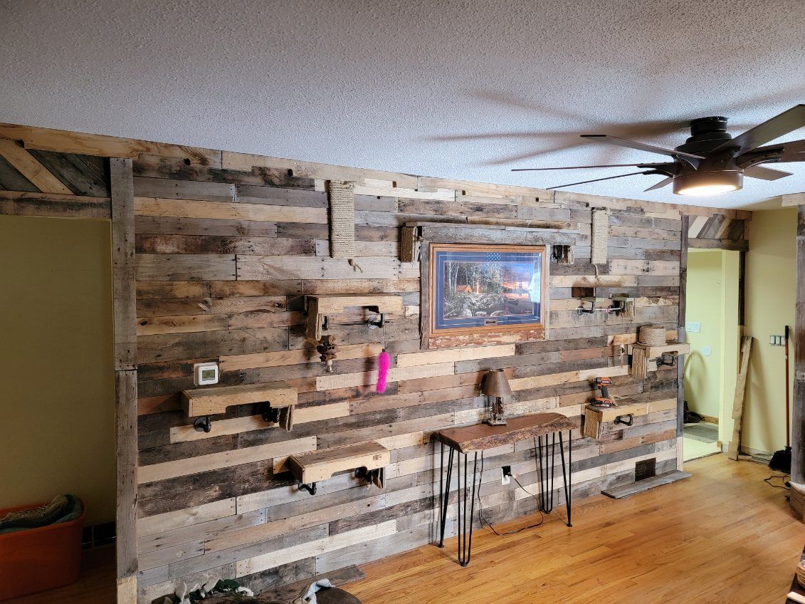 A living room with a wooden wall and a ceiling fan.