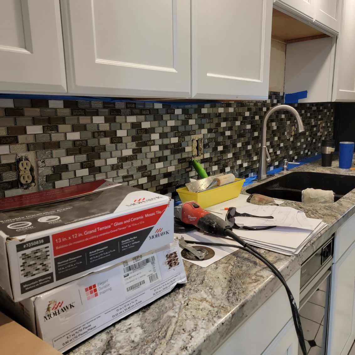 A kitchen counter with a stack of boxes on top of it.