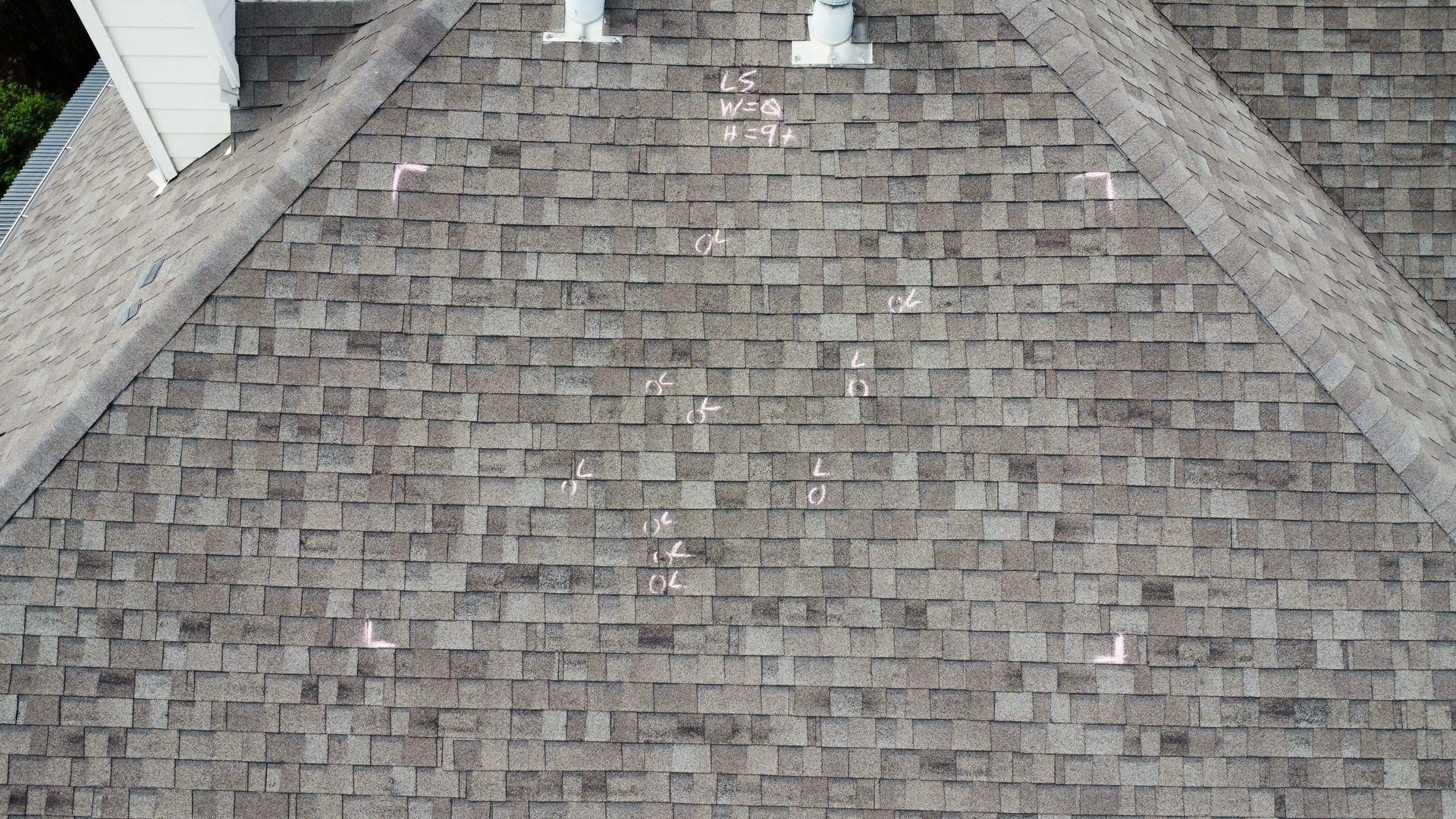 Overhead view of a shingled roof, with white markings indicating points of interest.