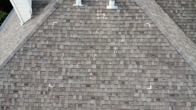 Roof Inspections - Phoenix Storm Restoration Overhead view of a shingled roof, with white markings indicating points of interest.