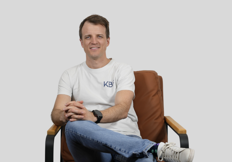 A man with his arms crossed wearing a black shirt that says kbs
