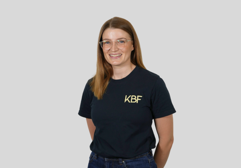 A woman wearing a black t-shirt with the letters kbf on it.