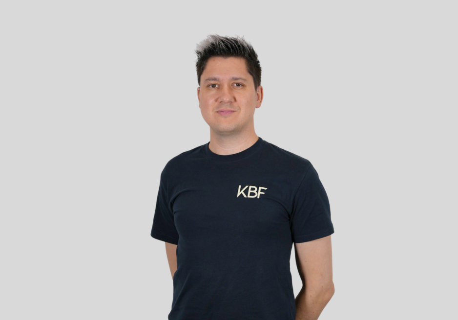 A man wearing a black t-shirt with the word kbf on it