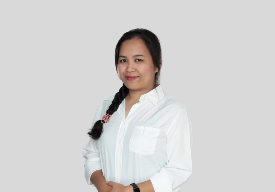 A woman in a white shirt is standing with her hands on her hips.