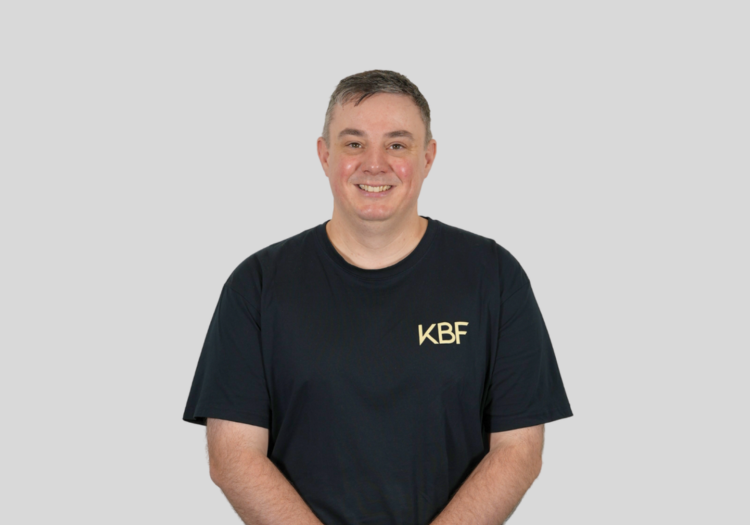 A man wearing a black shirt with the word kbf on it