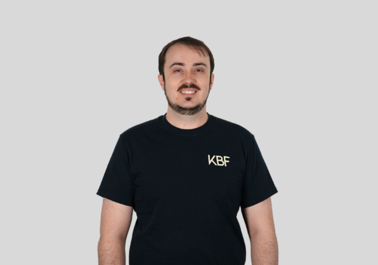A man wearing a black shirt that says kbf on it