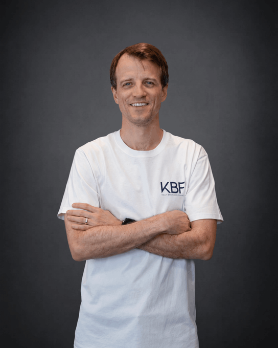 A man with his arms crossed wearing a black shirt that says kbs