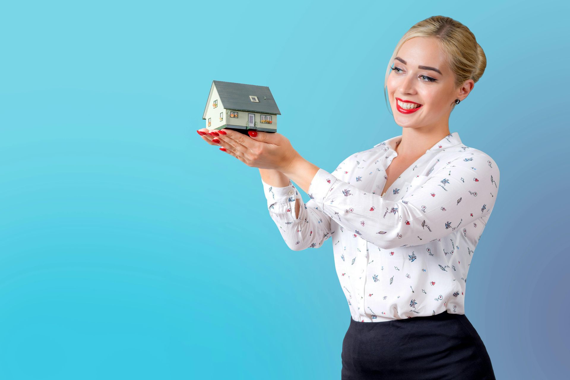 Woman in a white blouse holding a small house model against a blue background