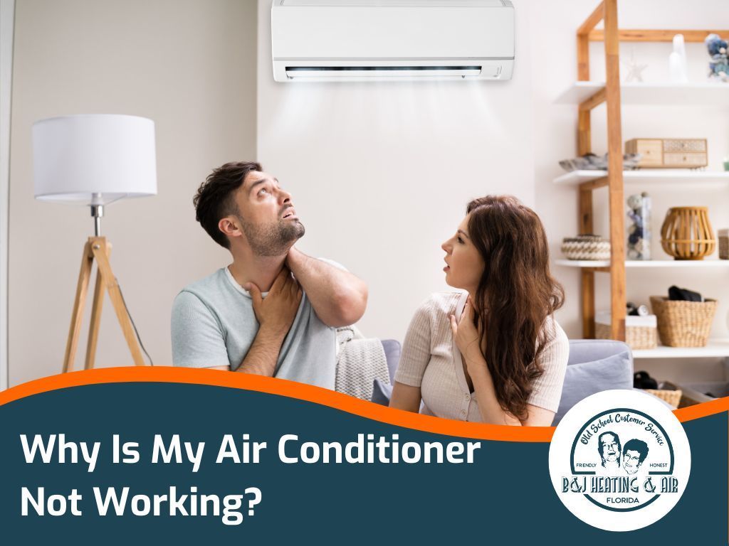 A man and a woman are sitting on a couch in front of an air conditioner.