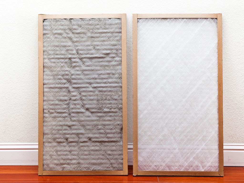 Two air filters are sitting on a wooden floor next to each other.