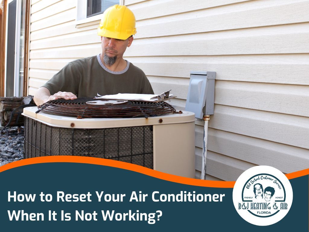 A man wearing a hard hat is working on an air conditioner outside of a house.