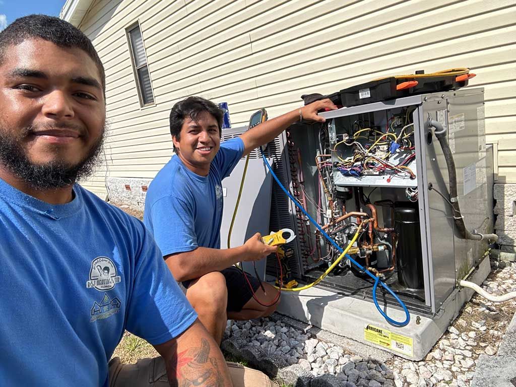 Two men are working on an air conditioner outside of a house.