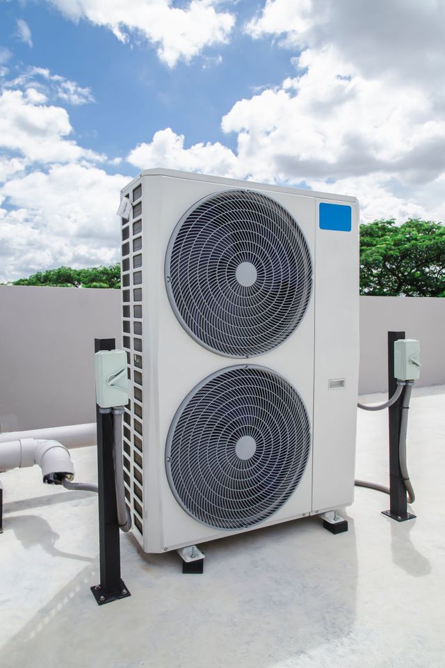 A large air conditioner is sitting on top of a roof.