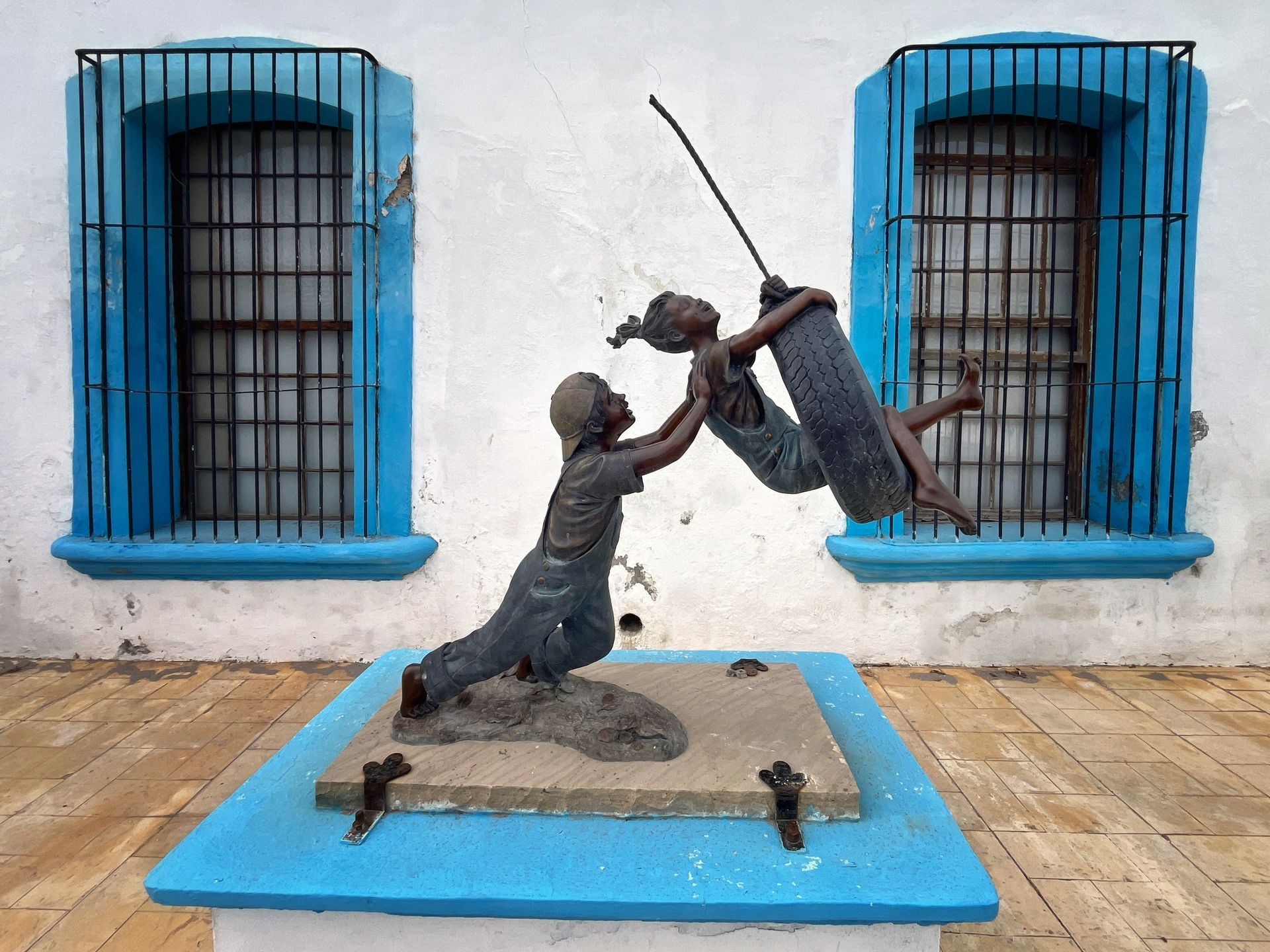 Statue of children play on a swing