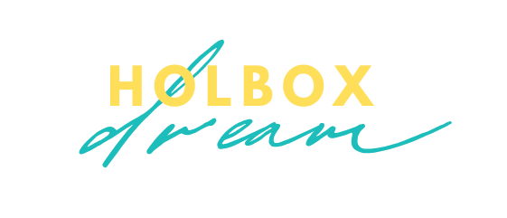 Logotipo: “HOLBOX” en amarillo, “dream” en cursiva verde azulado, ambos superpuestos con un remolino verde azulado.